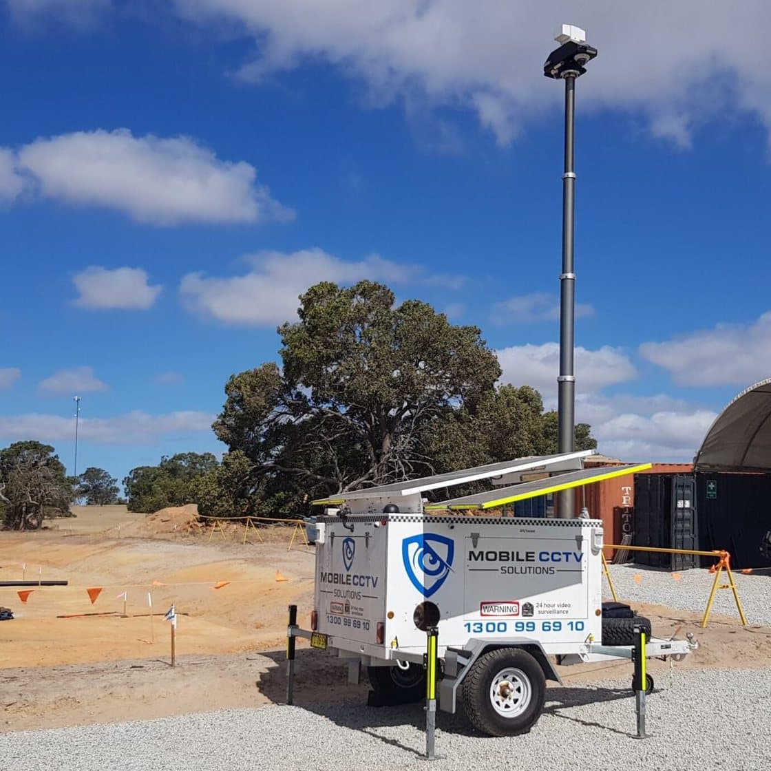 A Mobile CCTV Solutions trailer with raised mast deployed on a gravel construction site