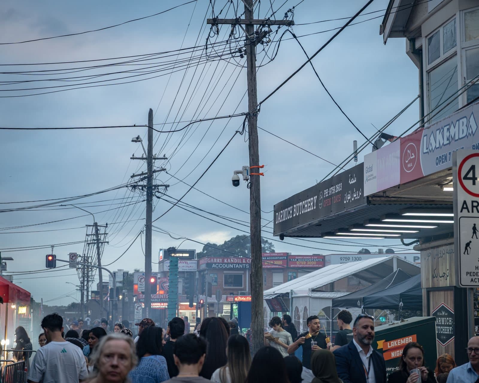 Cameras mounted on poles above a busy street at dusk