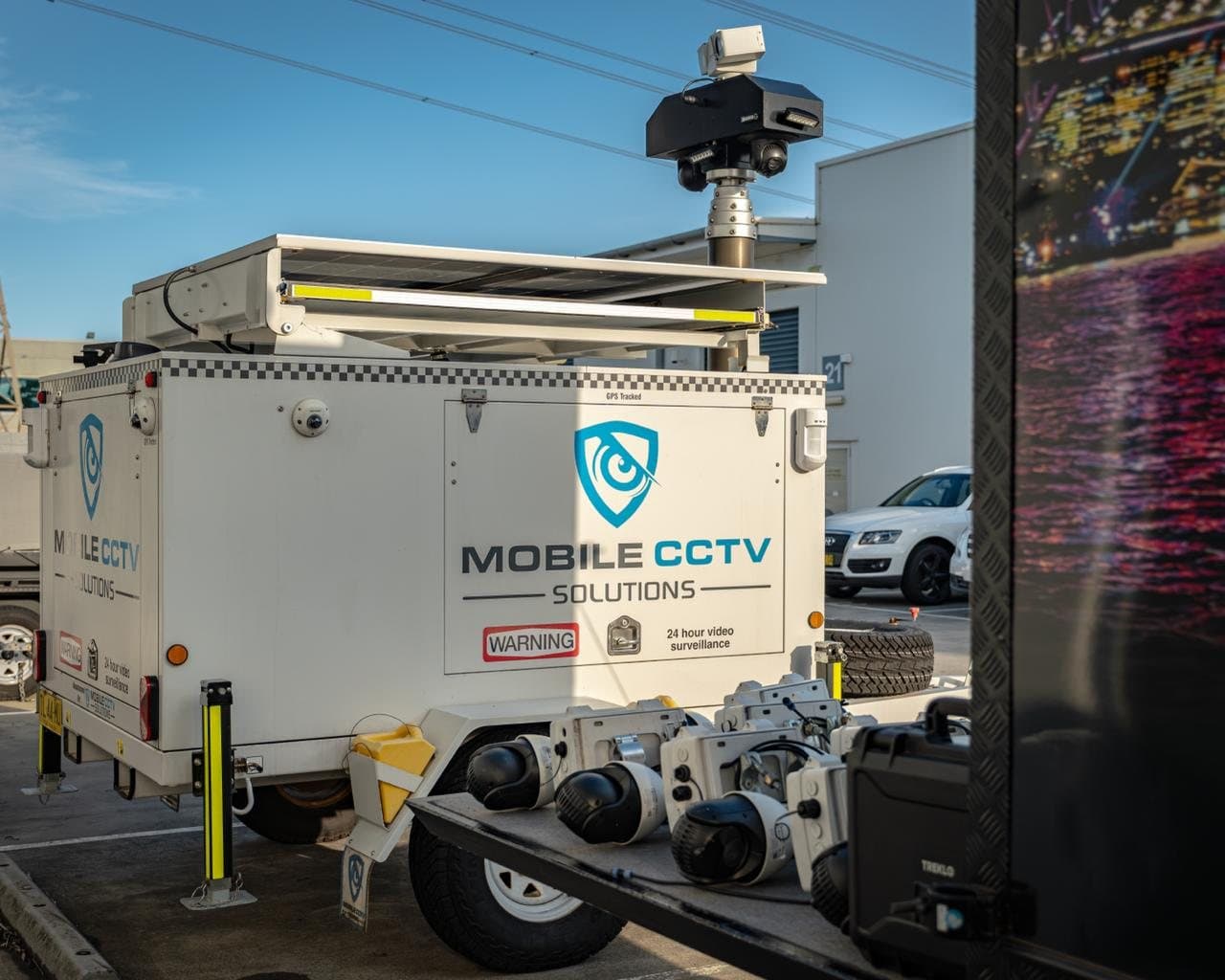 A Mobile CCTV Solutions trailer with raised camera mast, with spare cameras laid out on a tray in front